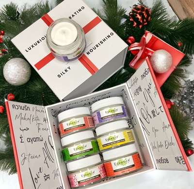 Body butter gift box set surrounded by boughs of evergreen and ornaments.