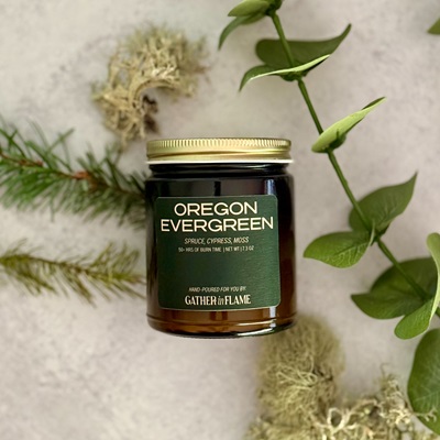 Oregon Evergreen candle surrounded by pine and moss and leaves