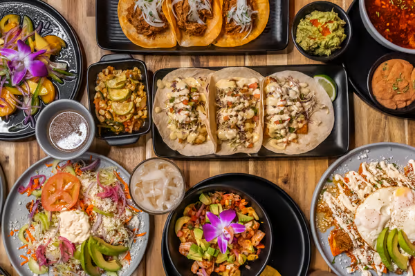 Table display of tacos, guacamole and more Mexican dishes from Tamale Boy