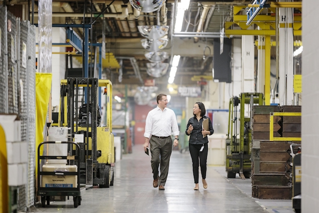 Workers discussing and walking in warehouse