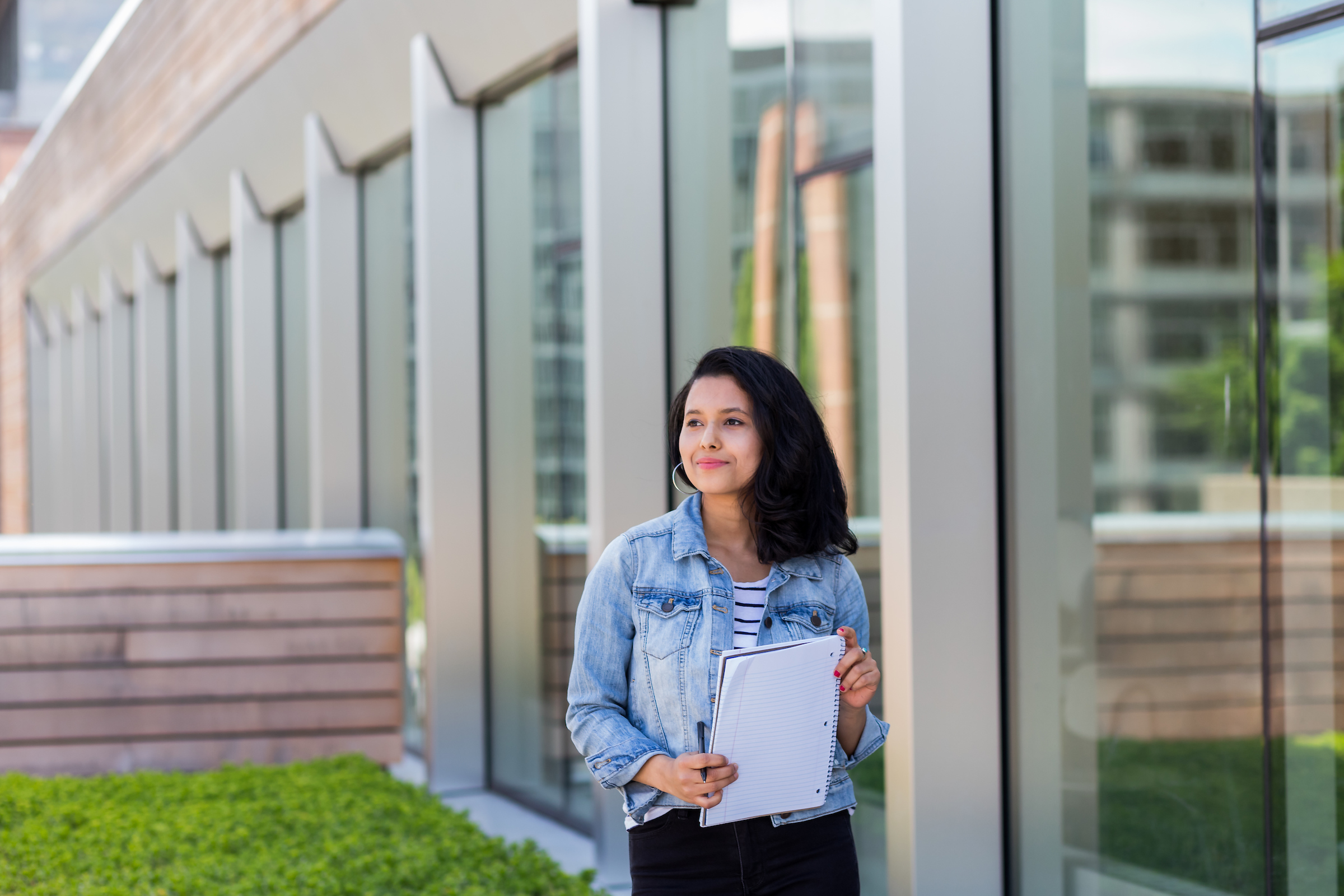 student standing in front of business school