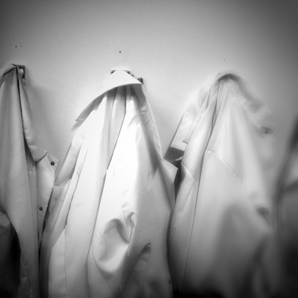 White Lab Coats on Wall Hooks