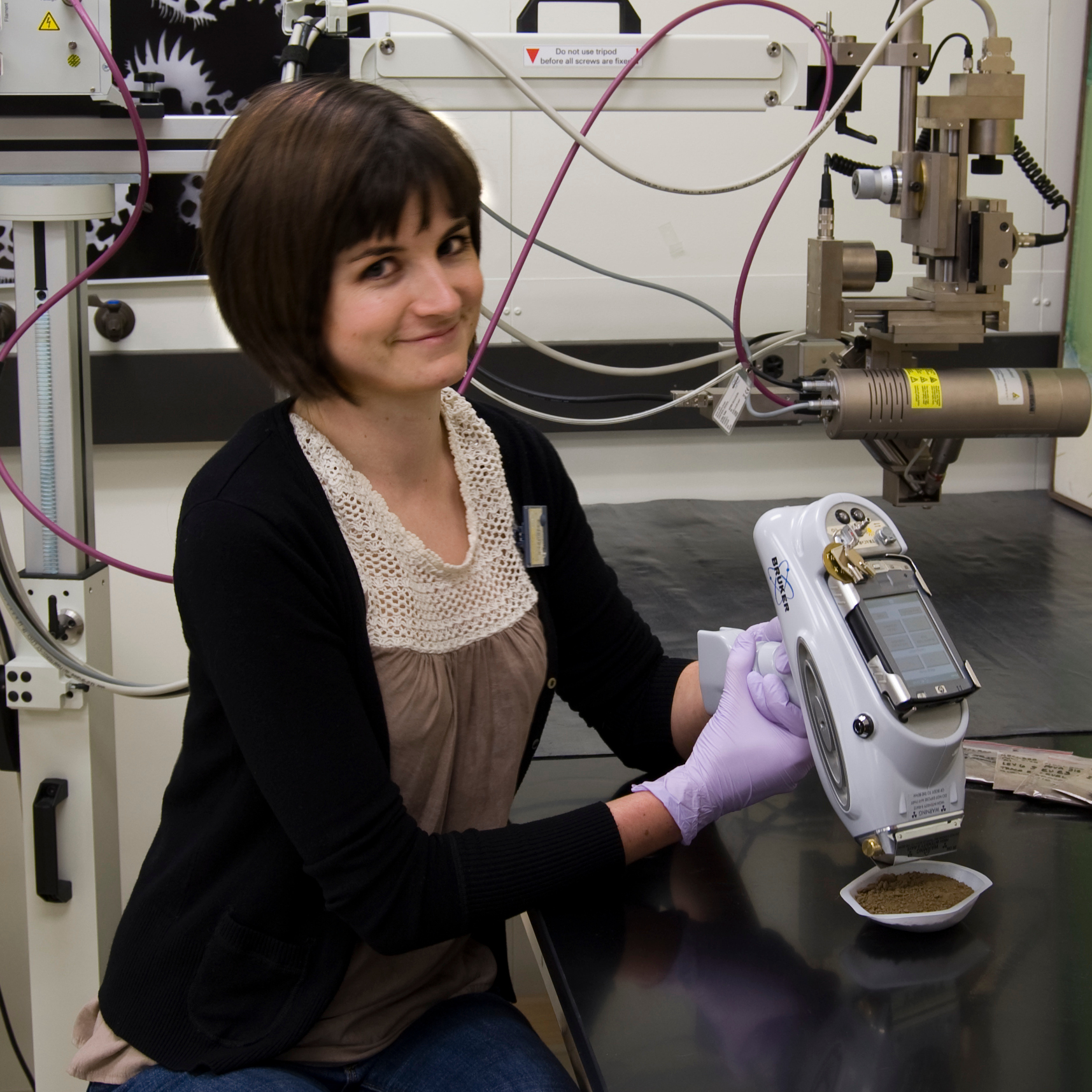 Capri holding portable XRF pointed at soil sample