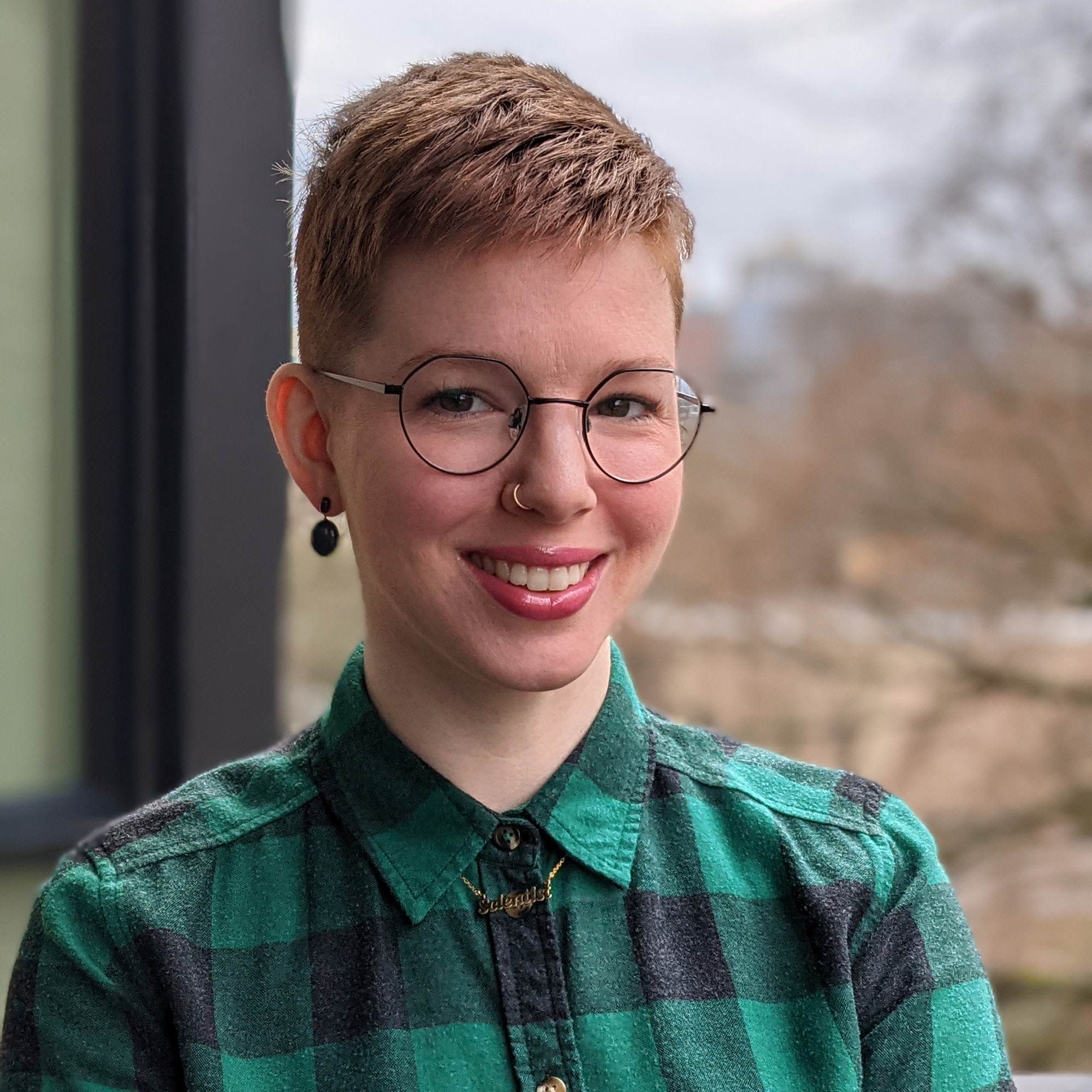 Lyndsay in green plaid shirt in front of window