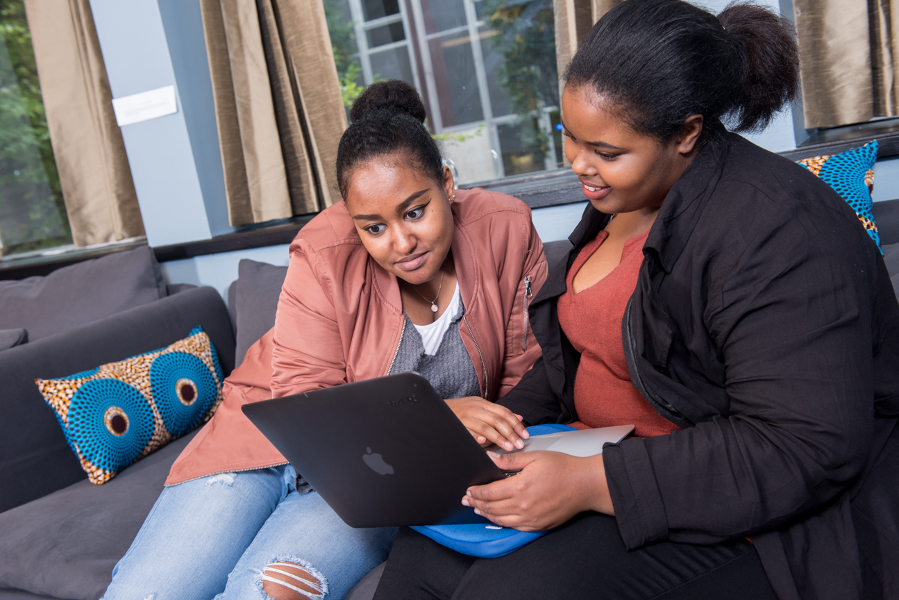 2 students in PAC looking at laptop