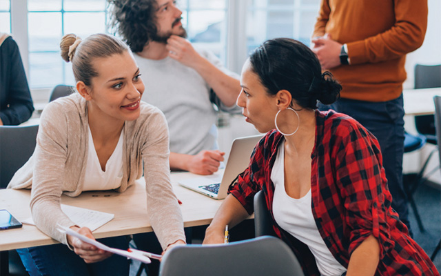 Two pairs of adults chat in class.