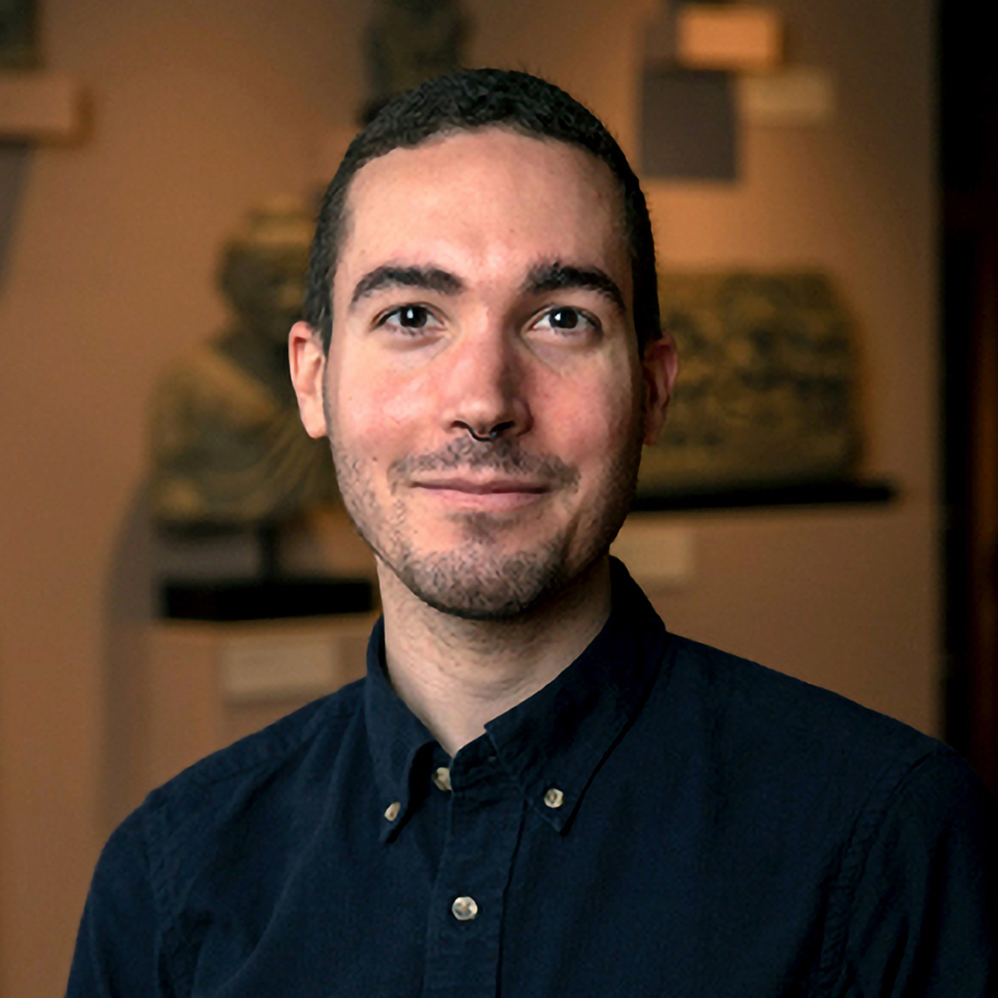 Man with dark hair and a dark button up shirt