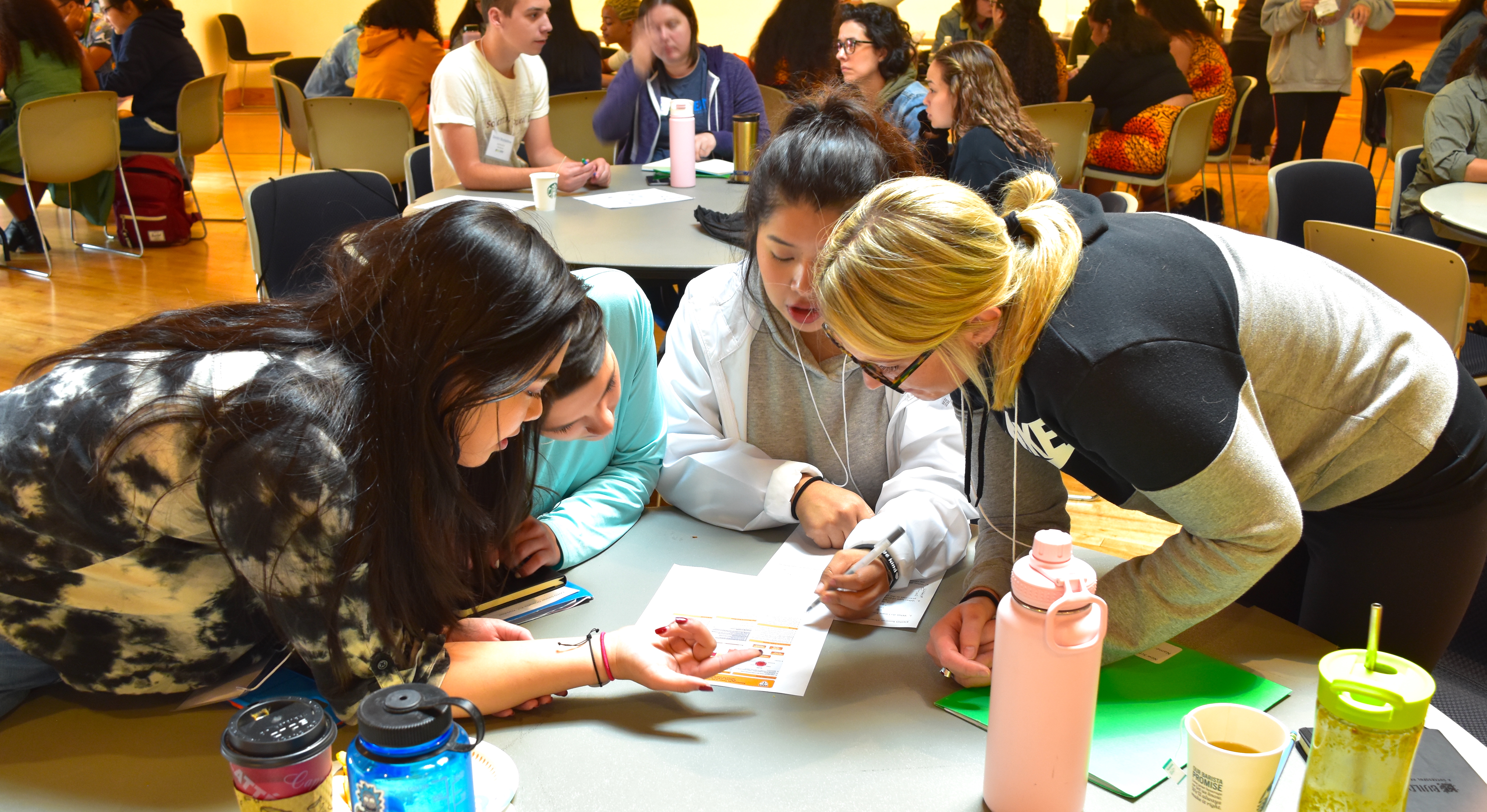 Students at a table look at a paper at new student orientation
