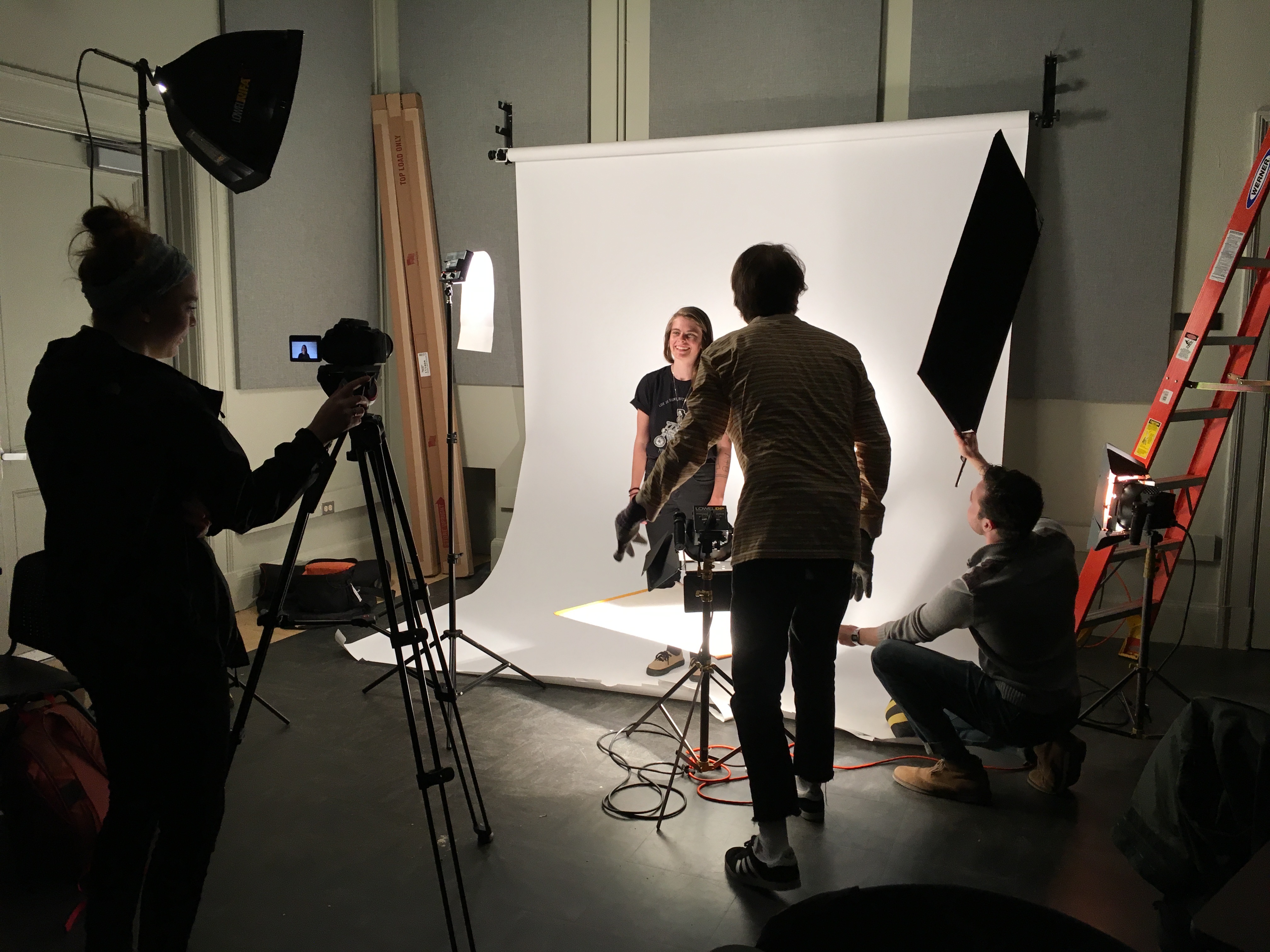 Student filming in front of white screen