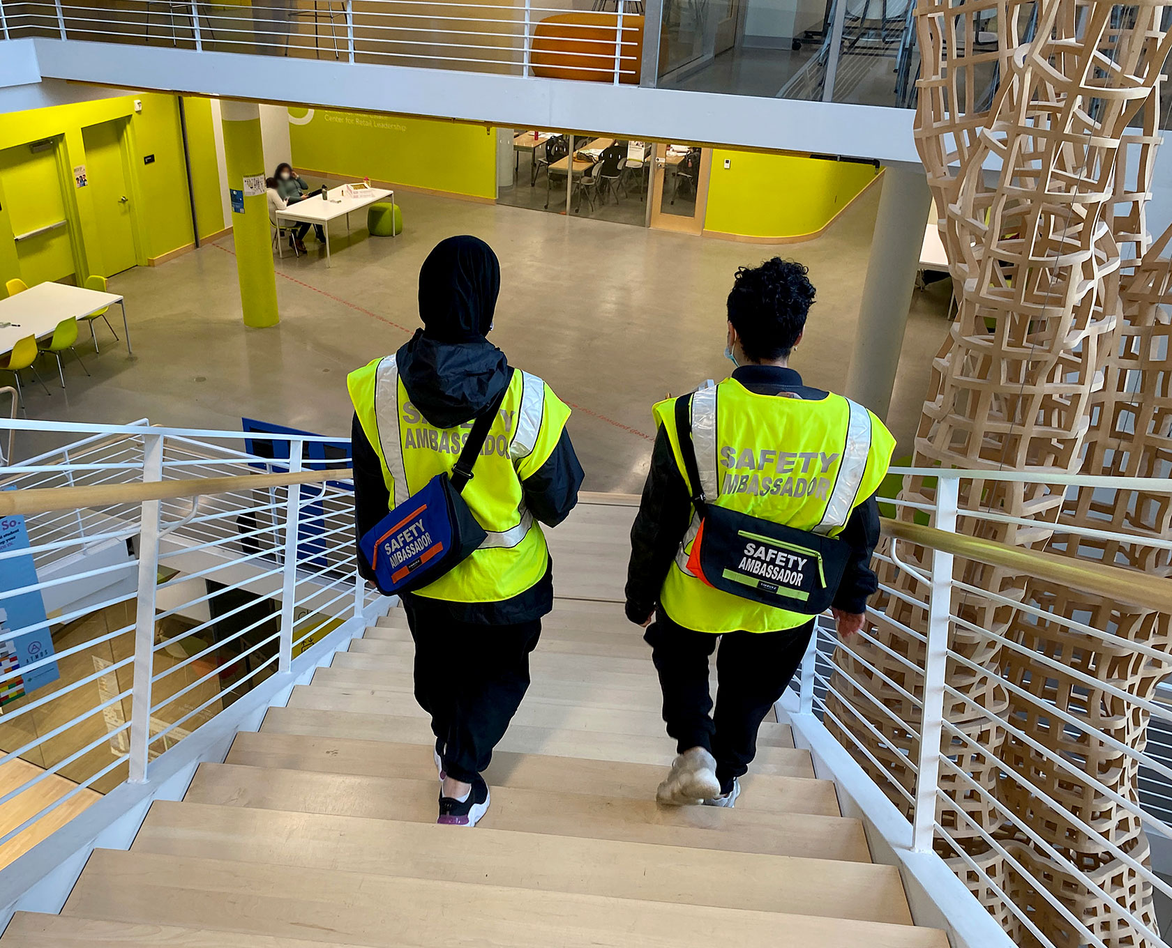 Two student safety ambassadors walk through the Karl Miller Center. Student safety ambassadors offer the campus community a direct link to the Campus Public Safety Office.