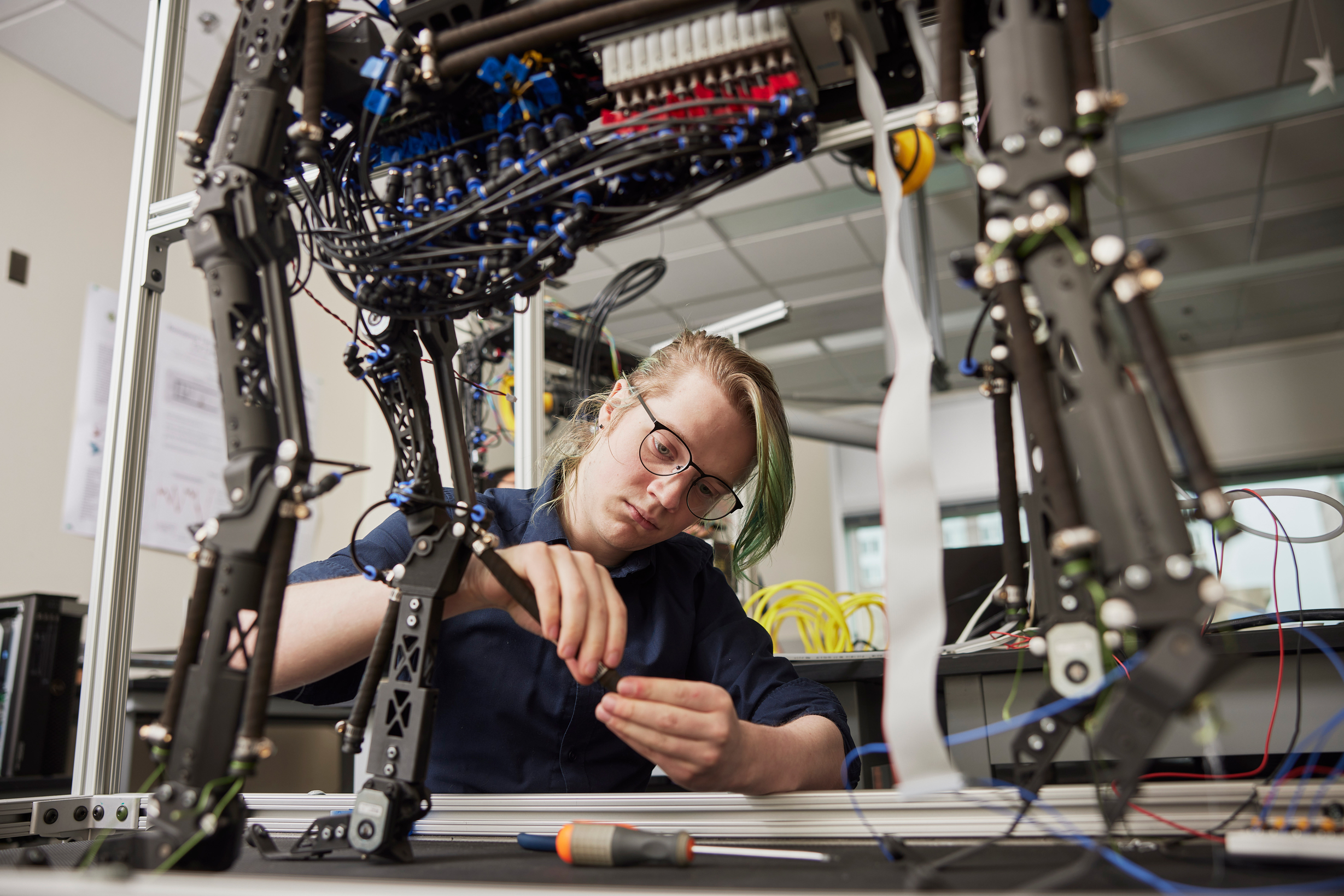PSU student working on a complex robotic structure in an engineering lab
