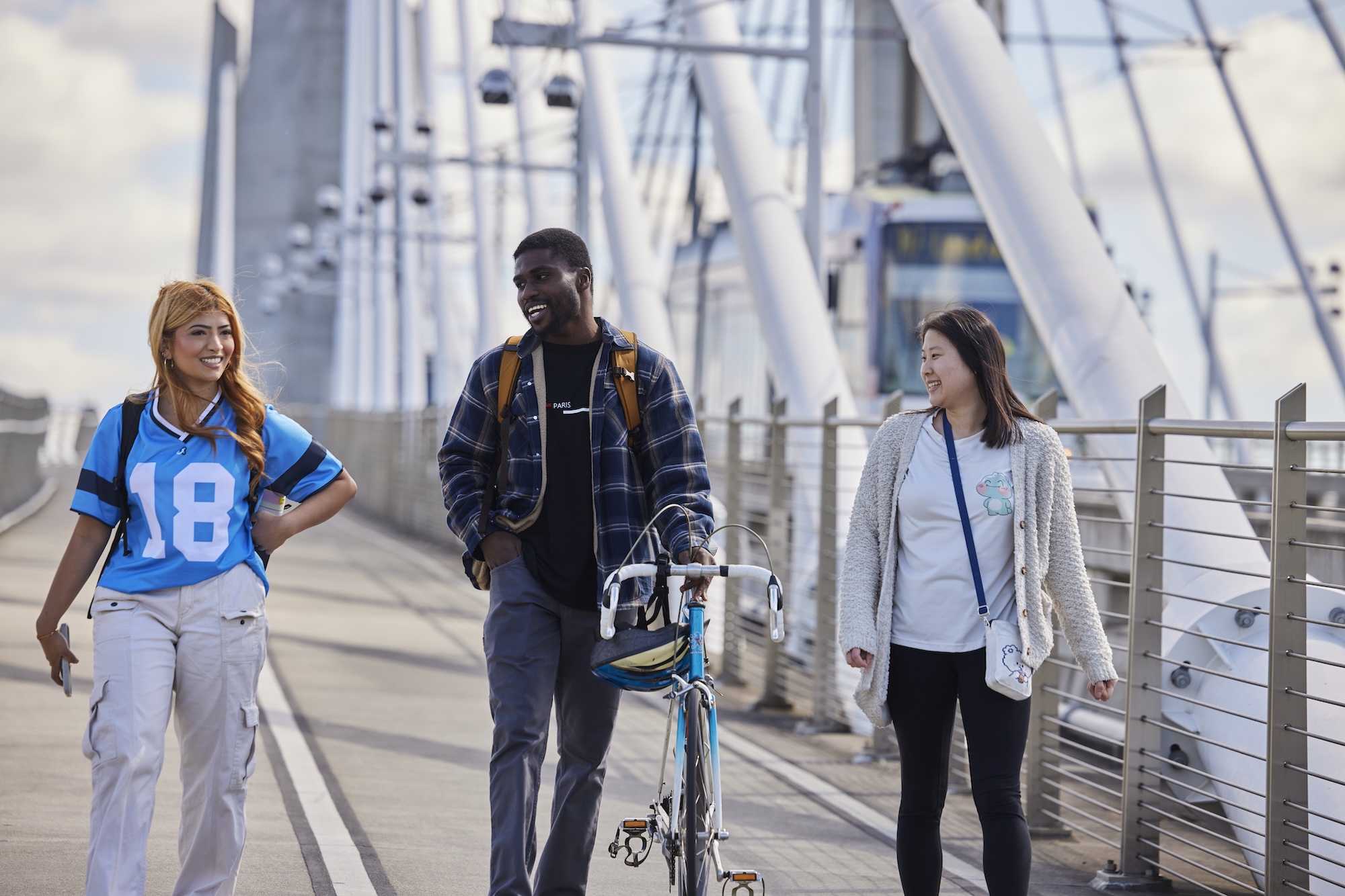 Three students walk across the Tillikum Crossing