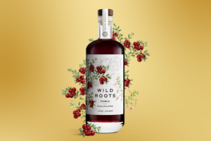 A bottle of Wild Roots cranberry vodka with a berry design behind it.