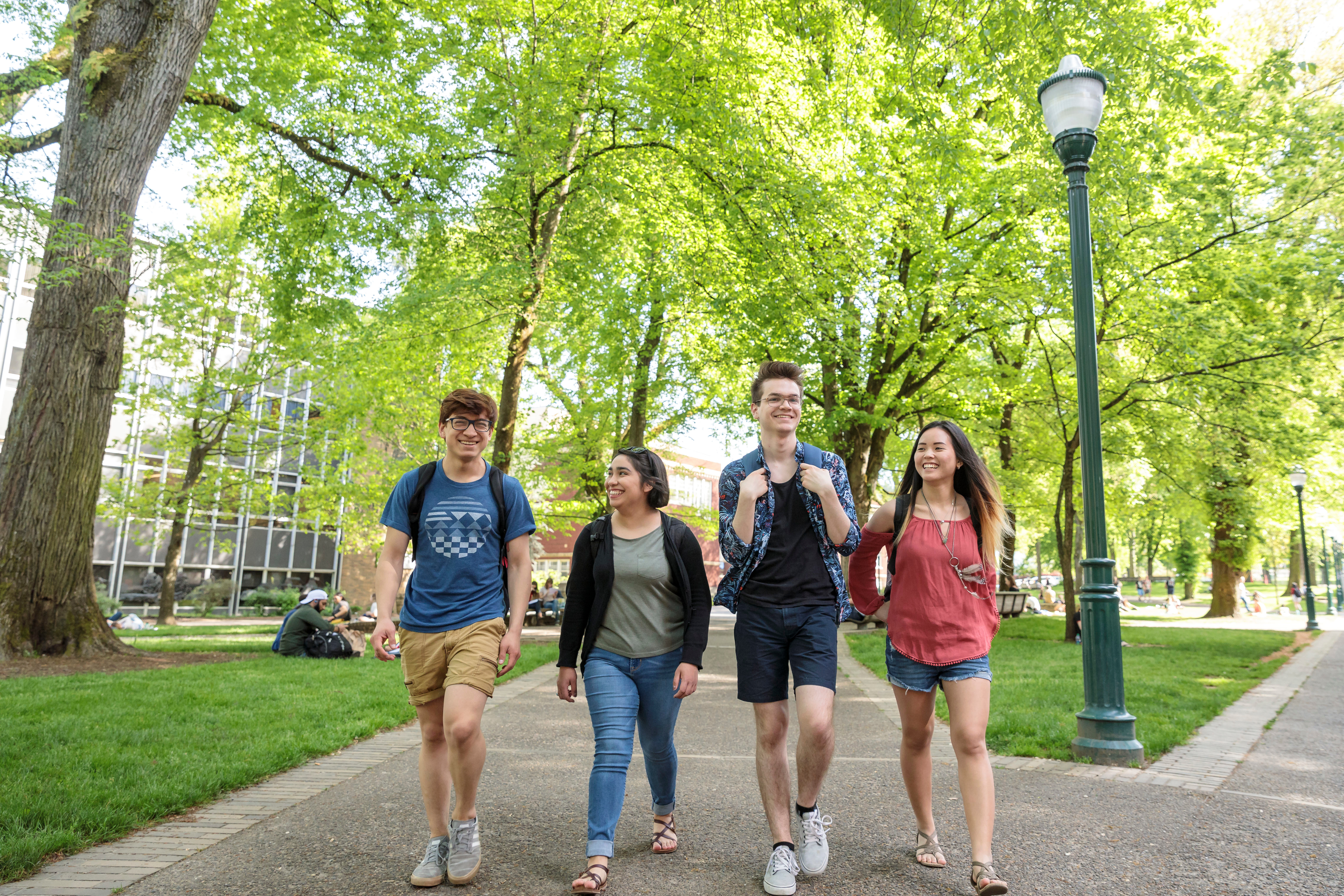a group of four students walks through PSU campus