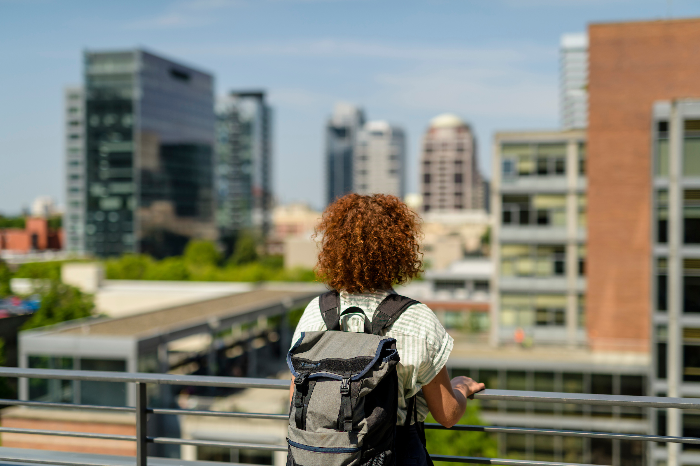 Back of woman with backpack looking at city